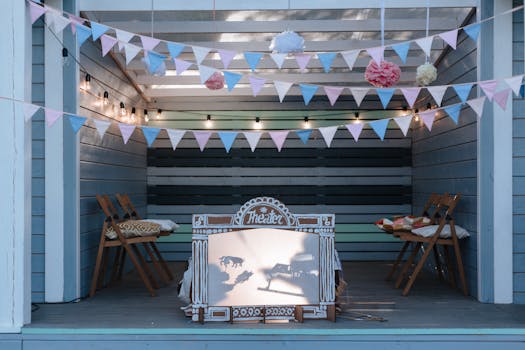 Cozy outdoor puppet theater setup with pastel pennants and folding chairs.